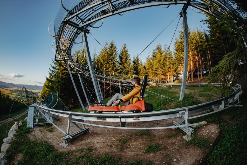 Aerial fisheye view of a rider on the alpine coaster near Lacul Roșu.