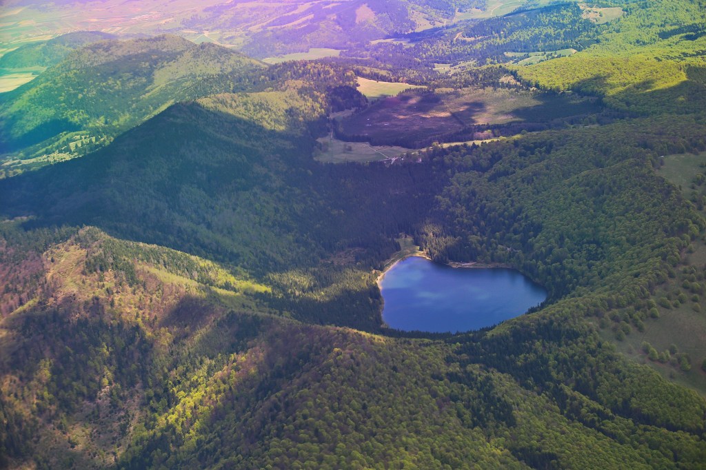 Aerial view of Lacul Sfânta Ana, a volcanic crater lake in Harghita County, Romania.