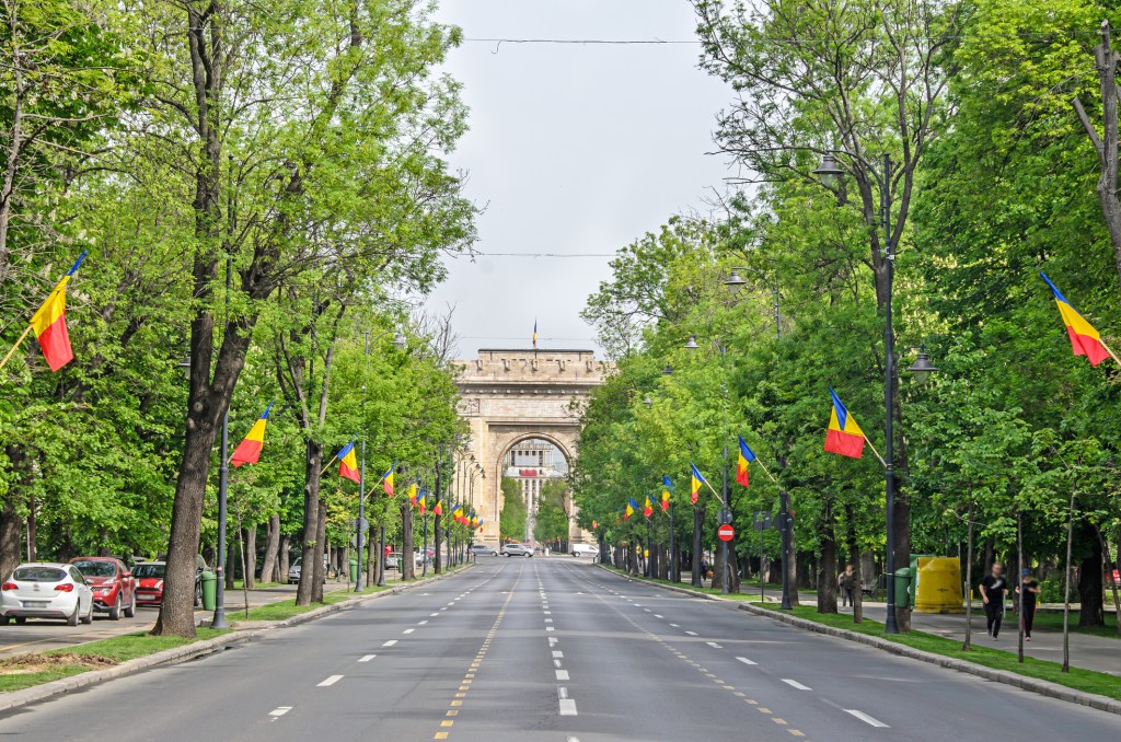 Arc de Triomphe sur le boulevard Kiseleff à Bucarest, Roumanie, bordé de drapeaux roumains