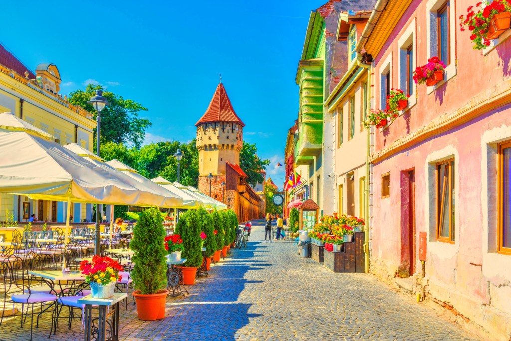 Piața Mică avec ses terrasses de café et la Tour des Charpentiers, dans la vieille ville de Sibiu.