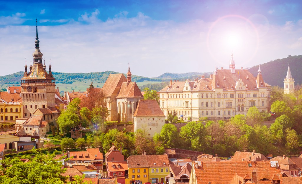 Panoramic view of Sighisoara citadel with Clock Tower and red rooftops, Transylvania, Romania