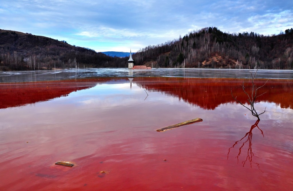 Lac toxique de Geamăna avec le clocher de l'église, Roumanie