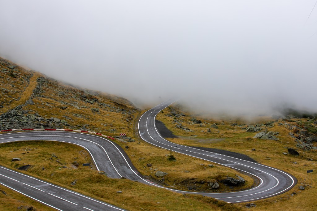 Fog rolling over the hairpin turns of the Transfăgărășan road, Romania.